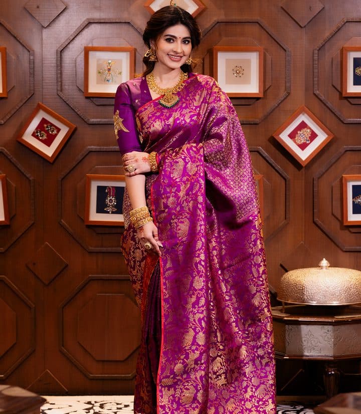Model in a magenta silk saree with gold zari motifs