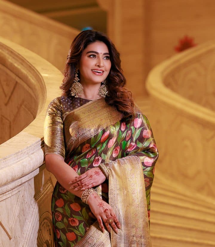 Model on a staircase in a green and gold zari Kanjivaram