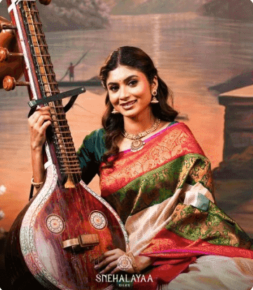 Model with a veena in a red and green silk saree