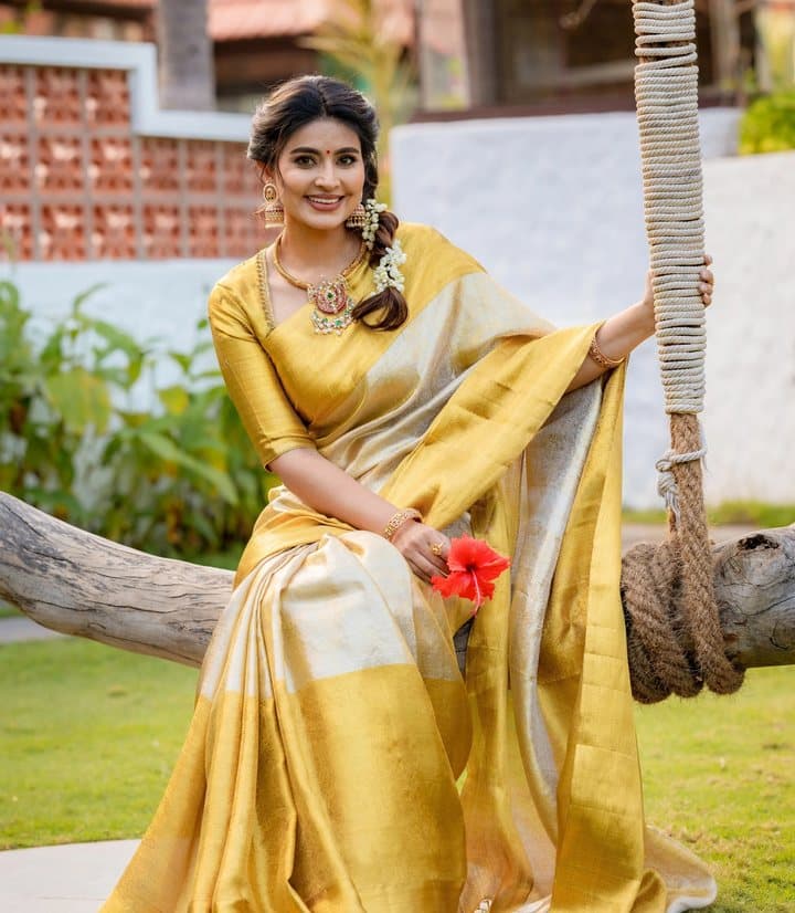 Model on a swing in a golden-yellow silk saree